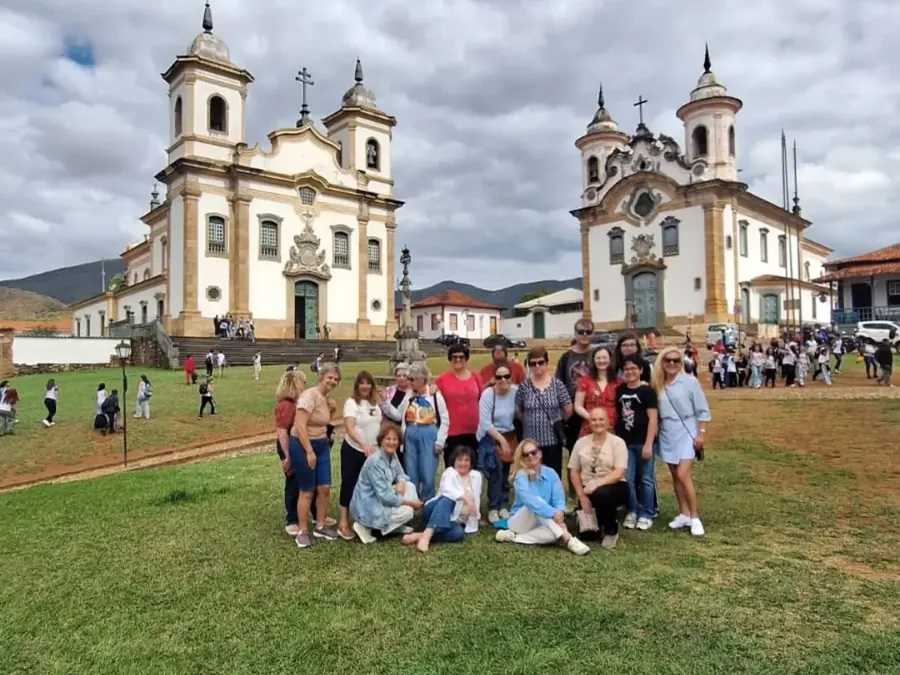Grupo de viajantes diante das igrejas históricas de Minas Gerais